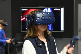 Eine junge Frau trägt eine Brille, um virtuelle Realität zu erleben.