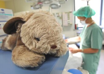 Ein Teddy liegt auf einer Krankenliege