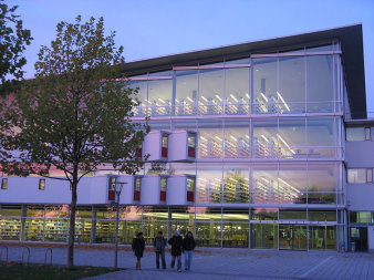 Foto: Bibliothek der Universität Erfurt © Universität Erfurt Außenansicht eines großen Gebäudes mit Glasfassade