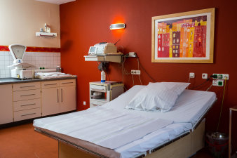 Foto: Kreisssaal © Helios Kliniken GmbH farbiger Raum mit größerem Bett, medizinischen Geräten und einer Waage