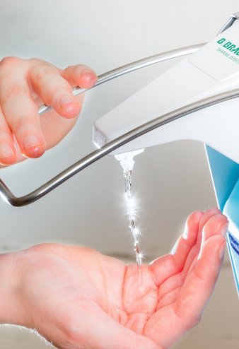 Foto: Händehygiene © Helios Kliniken GmbH Zwei Hände, die einen Desinfektionsspender betätigen.