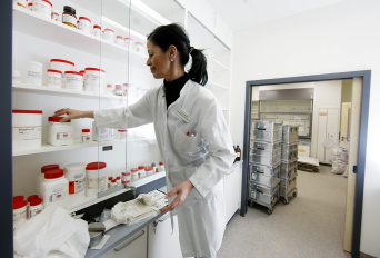 Foto: Apotheke © Helios Kliniken GmbH Apothekerin vor großem Dosenregal
