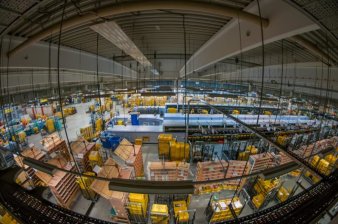 Foto: DP Briefzentrum Innenansicht © Frank Uebe Blick in eine Halle mit Regalen, Verteilsystemen und -anlagen in Fischaugen-Optik