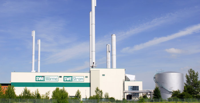 Foto: SWE © SWE Stadtwerke Erfurt GmbH Weißes Gebäude der Stadtwerke Erfurt mit den Aufschriften "SWE Wärme" und "SWE Strom" vor einem strahlend blauen Himmel mit Wolken.