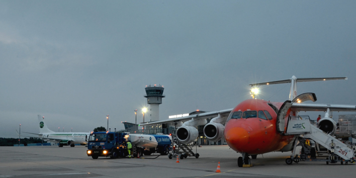 Foto: Abfertigung am Flughafen Erfurt-Weimar © Flughafen Erfurt-Weimar / Alice Koch Zwei Flugzeuge werden bei Dämmerung mit verschiedenen technischen Geräten von Mitarbeitern entladen und betankt, es gibt viele Lichter zu sehen