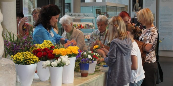 Foto: Florales © Annette Kummer mehrere Personen am Stand mit Blumen
