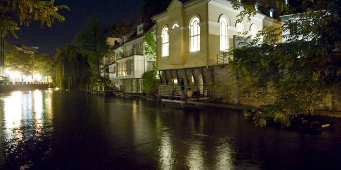 Foto: Kleine Synagoge bei Nacht © Stadtverwaltung Erfurt Erleuchtetes Gebäude der Synagoge bei Nacht. Lichter spiegeln sich im Wasser.