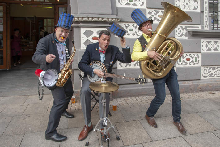 Musiker mit blauen Hüten empfangen vor dem Stadtmuseum