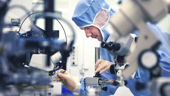 Ein Mann arbeitet mit Mikroskopen im Labor.