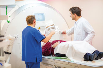 Foto: Radiologie © Helios Kliniken GmbH drei Menschen, einer in der MRT-Röhre