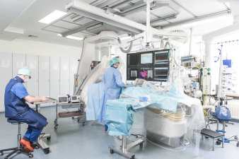 Foto: Virtuelle Kardiologie © Helios Kliniken GmbH Raum mit Personal, Technik und mehreren Monitoren