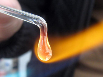 Foto: Glastropfen beim Erhitzen mit Feuerflamme © Sebastian Strobl Glasstab in Flamm mit Tropfenbildung