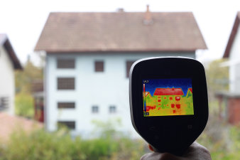 Foto: Bauthermographie eines Gebäudes mit Infrarotkamera © coourbox.de Messgerät mit Infrarotbild